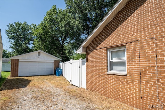 2004 Cottage Ave, Granite City, IL 62040 - view of side of home with brick siding, an outbuilding, a detached garage, and driveway