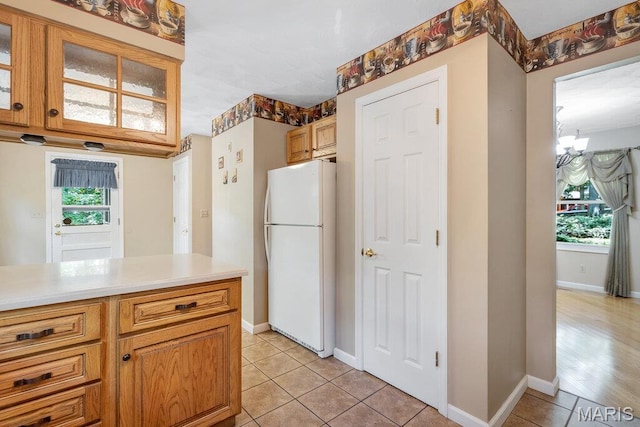 127 Hilltop Trl, Eureka, MO 63025 - kitchen featuring freestanding refrigerator, light tile patterned floors, light countertops, and glass insert cabinets