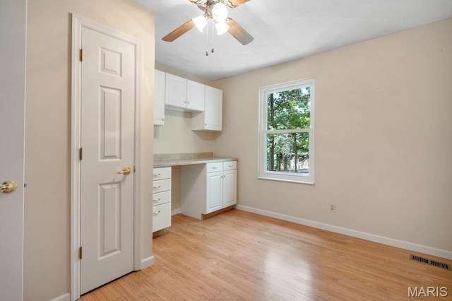 127 Hilltop Trl, Eureka, MO 63025 - kitchen with white cabinetry, a ceiling fan, built in desk, light wood finished floors, and light countertops