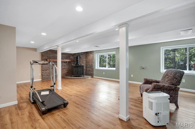 127 Hilltop Trl, Eureka, MO 63025 - exercise area with a wood stove, wood finished floors, brick wall, ornate columns, and recessed lighting