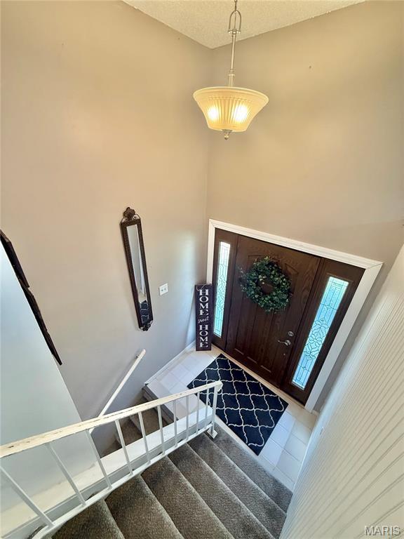 2284 Sunnyridge Dr, Arnold, MO 63010 - entryway featuring tile patterned floors, stairway, and a high ceiling
