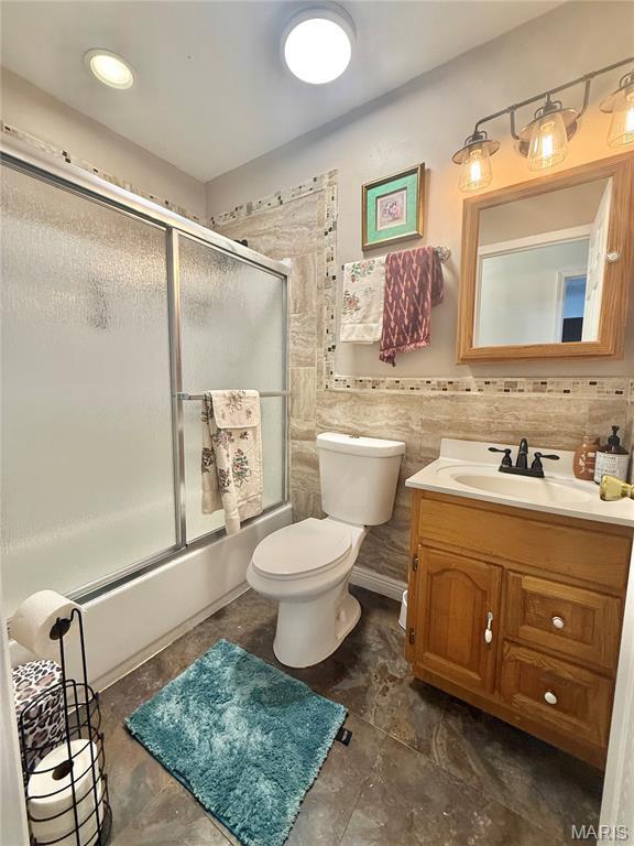 2284 Sunnyridge Dr, Arnold, MO 63010 - bathroom with vanity, combined bath / shower with glass door, and tile walls