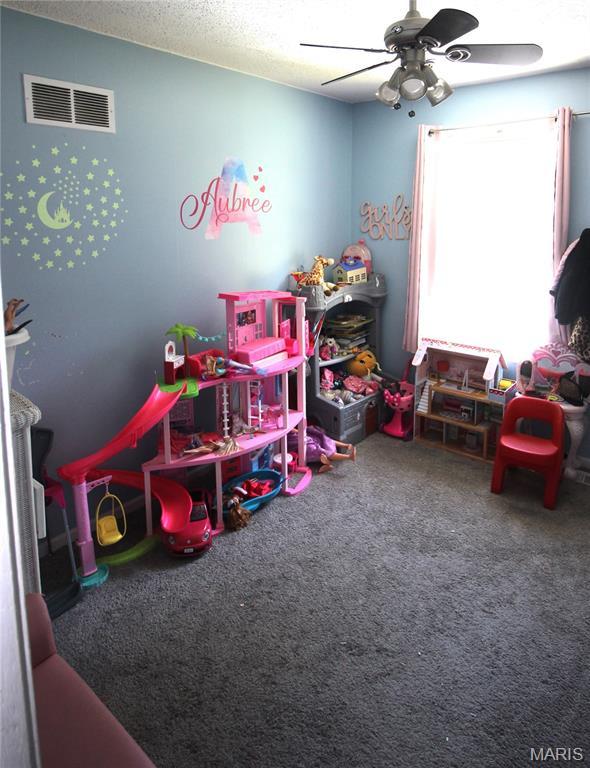 2890 Tommy Dr, Arnold, MO 63010 - playroom featuring carpet floors, ceiling fan, and a textured ceiling