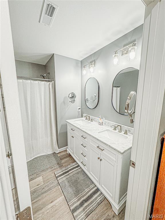 9 Powers Ln, Sikeston, MO 63801 - bathroom with wood finished floors, double vanity, and curtained shower