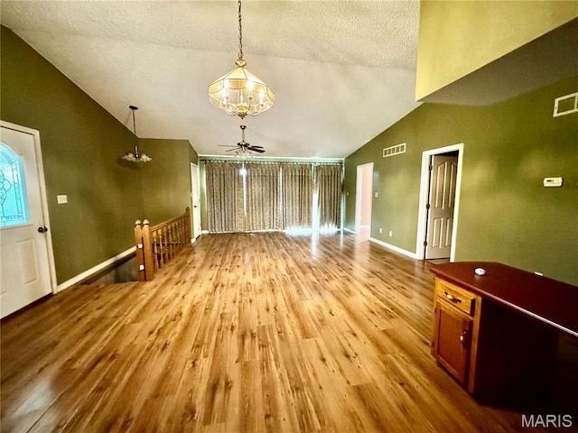 5250 Wren Ln, Osage Beach, MO 65065 - unfurnished living room featuring vaulted ceiling, wood finished floors, ceiling fan, and a textured ceiling