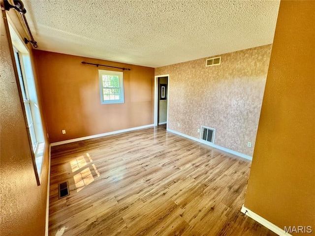 5250 Wren Ln, Osage Beach, MO 65065 - spare room with wood finished floors, a textured ceiling, and a textured wall