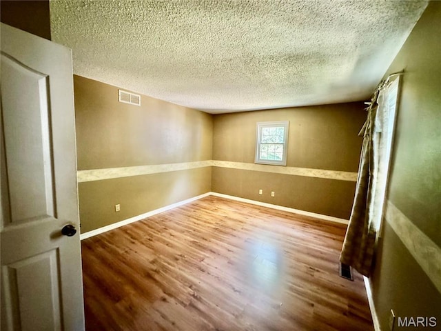 5250 Wren Ln, Osage Beach, MO 65065 - unfurnished room with wood finished floors and a textured ceiling