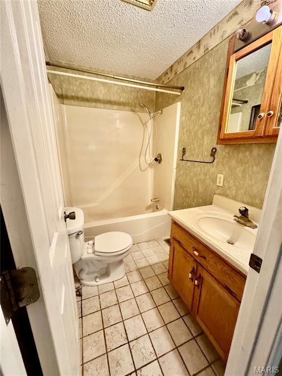 5250 Wren Ln, Osage Beach, MO 65065 - full bathroom featuring a textured ceiling, shower / bath combination, vanity, and tile patterned floors