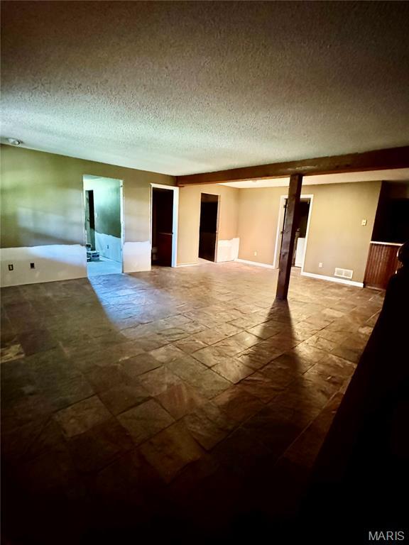 5250 Wren Ln, Osage Beach, MO 65065 - empty room with a textured ceiling and stone finish floors