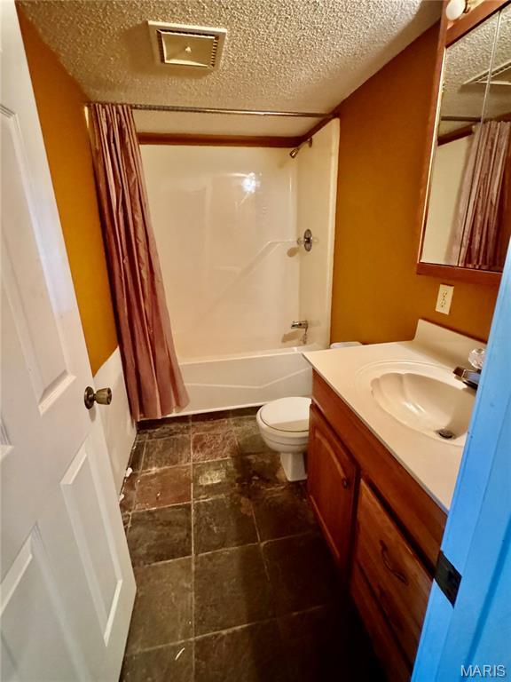 5250 Wren Ln, Osage Beach, MO 65065 - bathroom featuring vanity, shower / tub combo, and a textured ceiling