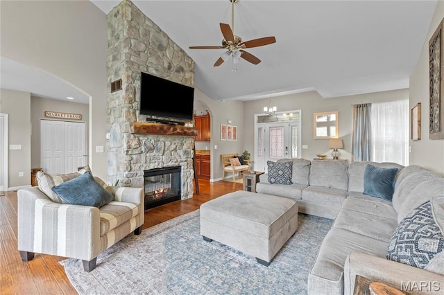 9882 W Vista Dr, Hillsboro, MO 63050 - living room featuring wood finished floors, a ceiling fan, a stone fireplace, arched walkways, and high vaulted ceiling