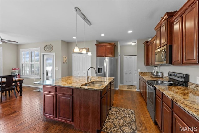 9882 W Vista Dr, Hillsboro, MO 63050 - kitchen featuring stainless steel appliances, dark wood-style flooring, light stone countertops, ceiling fan, and an island with sink