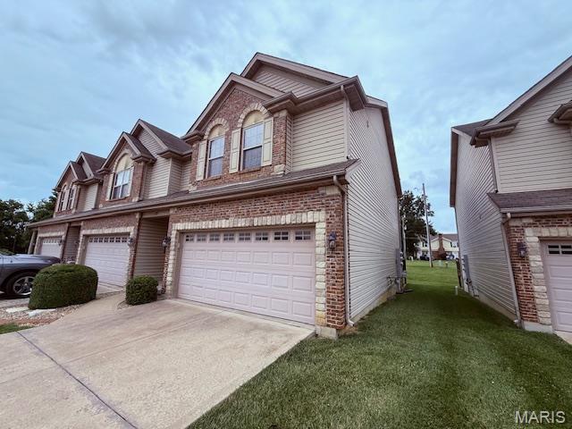 205 Prominence Ln, Lake St Louis, MO 63367 - traditional-style house featuring a front lawn, brick siding, concrete driveway, and a garage