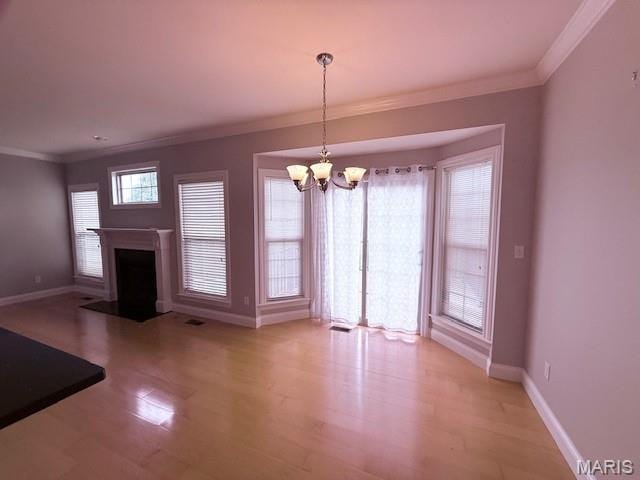 205 Prominence Ln, Lake St Louis, MO 63367 - unfurnished living room featuring crown molding, a chandelier, light wood-type flooring, and a fireplace with flush hearth
