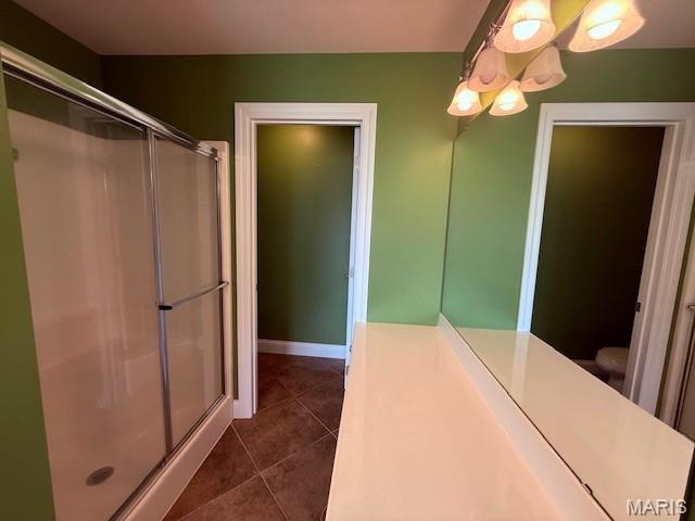 205 Prominence Ln, Lake St Louis, MO 63367 - bathroom featuring a stall shower, tile patterned floors, and a chandelier