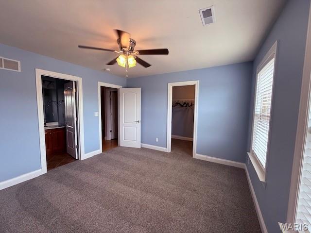 205 Prominence Ln, Lake St Louis, MO 63367 - unfurnished bedroom featuring multiple windows, carpet flooring, a walk in closet, and connected bathroom
