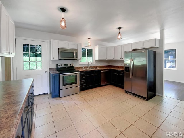 68 W Lakewood Dr, Fenton, MO 63026 - kitchen featuring stainless steel appliances, healthy amount of natural light, light tile patterned floors, and pendant lighting