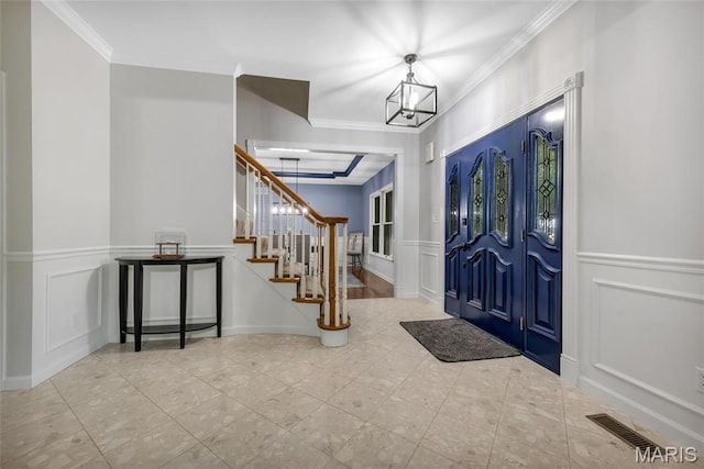 16517 Lancaster Estates Dr, Grover, MO 63040 - foyer entrance with a decorative wall, crown molding, stairway, a chandelier, and a wainscoted wall