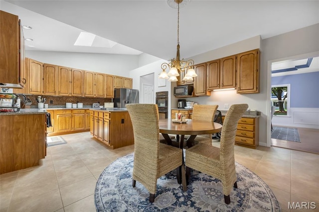 16517 Lancaster Estates Dr, Grover, MO 63040 - dining space with a skylight, light tile patterned flooring, lofted ceiling, and a chandelier