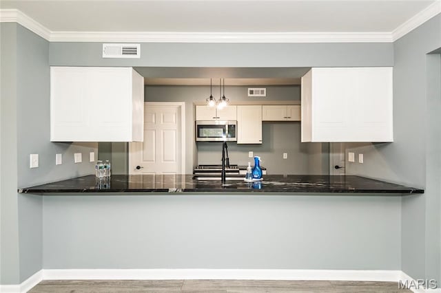 3624 Colonia Pl Unit B, Saint Louis, MO 63125 - kitchen featuring stainless steel microwave, a peninsula, dark stone countertops, and crown molding