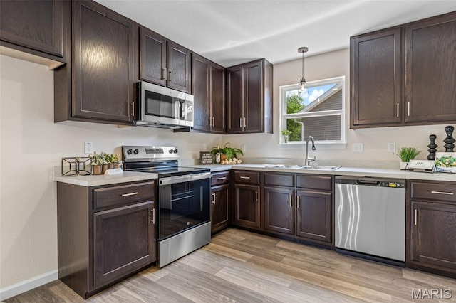 1917 Magnolia Way, Pevely, MO 63070 - kitchen with stainless steel appliances, light countertops, dark brown cabinets, and light wood finished floors