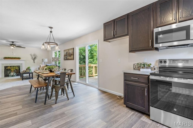 1917 Magnolia Way, Pevely, MO 63070 - dining area featuring light wood finished floors, a fireplace, and ceiling fan