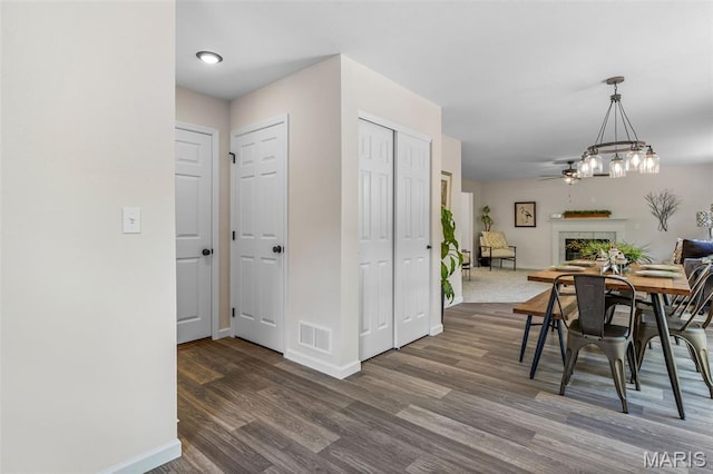 1917 Magnolia Way, Pevely, MO 63070 - dining room with dark wood-style floors, a fireplace, and a chandelier