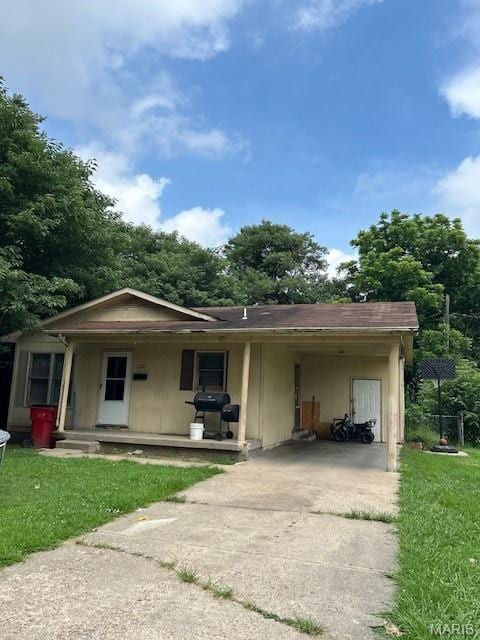 408 Carroll St, Sikeston, MO 63801 - view of front of home featuring concrete driveway, an attached carport, a front yard, and covered porch