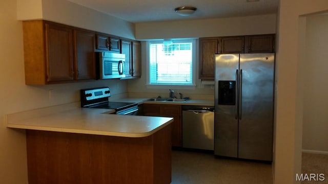 2244 Canyonlands Dr Unit B, Maryland Heights, MO 63043 - kitchen with appliances with stainless steel finishes, a peninsula, light countertops, and brown cabinetry