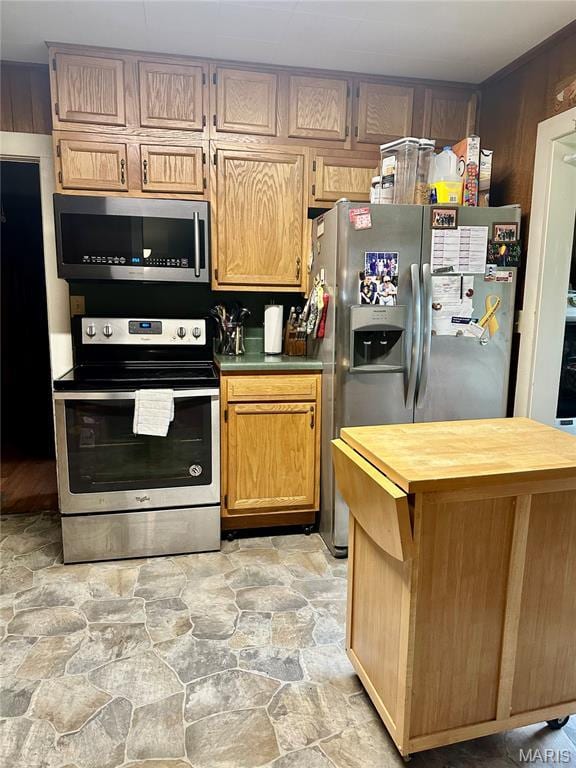 206 Cedar, Bertrand, MO 63823 - kitchen with appliances with stainless steel finishes, wood counters, light stone finish flooring, and a center island