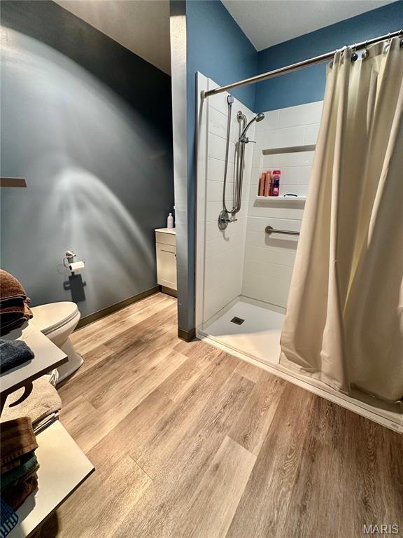 206 Cedar, Bertrand, MO 63823 - bathroom featuring wood finished floors and a stall shower