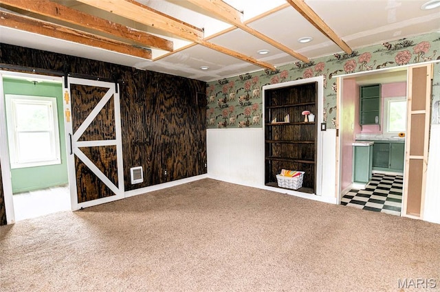 15902 County Road 7520, Newburg, MO 65550 - spare room featuring a wainscoted wall, wallpapered walls, a barn door, and carpet flooring