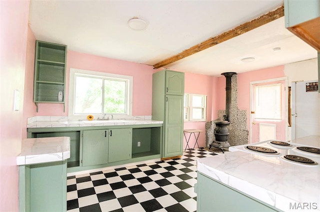 15902 County Road 7520, Newburg, MO 65550 - kitchen featuring green cabinets, tile patterned floors, beam ceiling, a wood stove, and tile counters