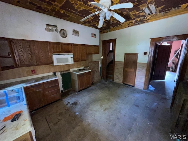 1063 Hornsby Ave, Saint Louis, MO 63147 - kitchen featuring white microwave, ceiling fan, and a wainscoted wall