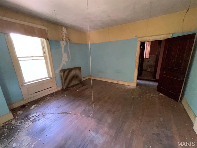 1063 Hornsby Ave, Saint Louis, MO 63147 - unfurnished bedroom with radiator heating unit and wood finished floors