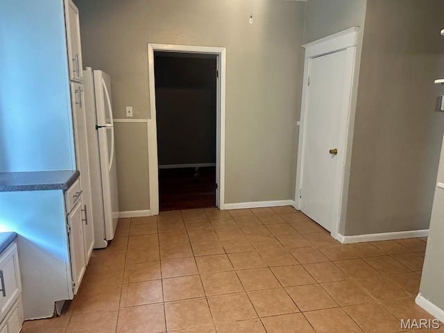 6624 Bartmer Ave, University City, MO 63130 - kitchen featuring light tile patterned floors, white cabinetry, freestanding refrigerator, and dark countertops
