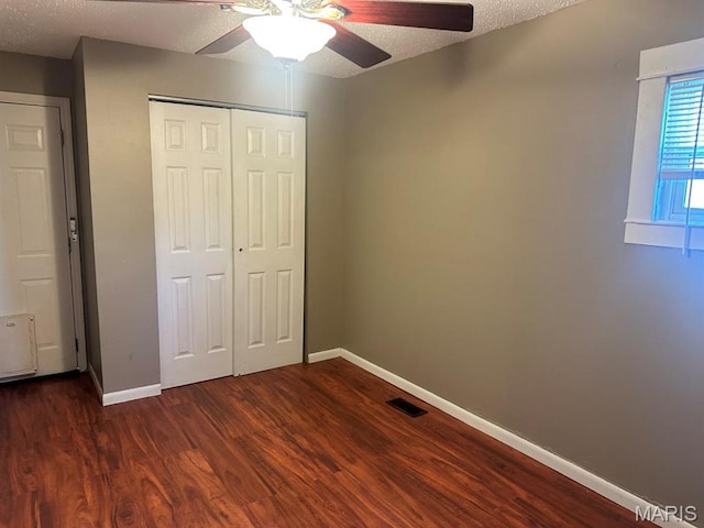 6624 Bartmer Ave, University City, MO 63130 - unfurnished bedroom with dark wood-style flooring, a closet, a ceiling fan, and a textured ceiling