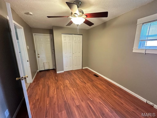6624 Bartmer Ave, University City, MO 63130 - unfurnished bedroom with wood finished floors, a textured ceiling, a closet, and ceiling fan