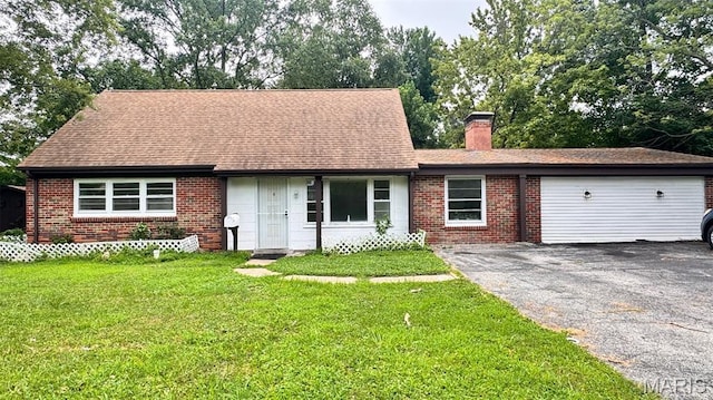 3400 Adie Rd, Saint Ann, MO 63074 - view of front of home featuring asphalt driveway, brick siding, a chimney, a garage, and a front yard