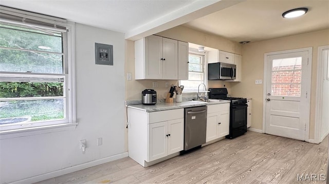 3400 Adie Rd, Saint Ann, MO 63074 - kitchen with stainless steel appliances, light wood finished floors, light countertops, and healthy amount of natural light