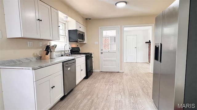 3400 Adie Rd, Saint Ann, MO 63074 - kitchen featuring stainless steel appliances, light countertops, white cabinetry, and light wood-style floors