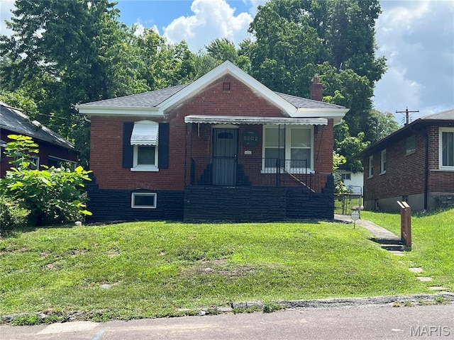 5502 Helen Ave, Saint Louis, MO 63136 - bungalow-style house with brick siding, a chimney, a front yard, and covered porch