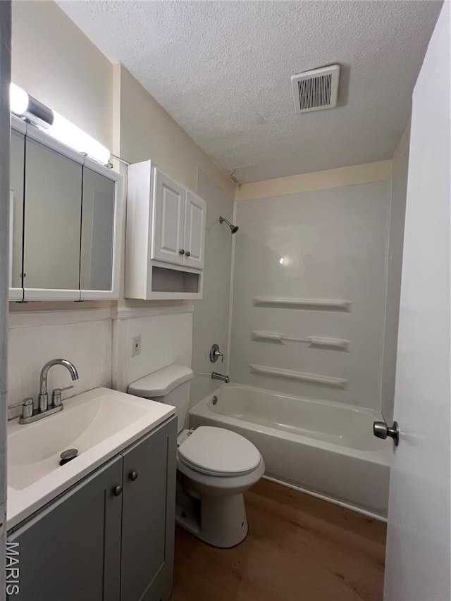 5502 Helen Ave, Saint Louis, MO 63136 - full bath featuring wood finished floors, a textured ceiling, tub / shower combination, and vanity