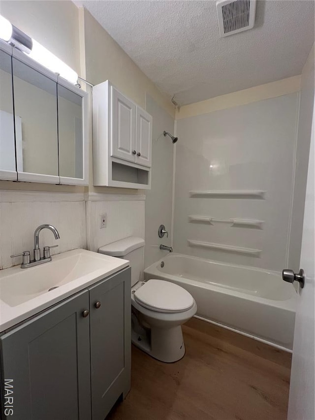 5502 Helen Ave, Saint Louis, MO 63136 - bathroom featuring wood finished floors, vanity, bathing tub / shower combination, and a textured ceiling