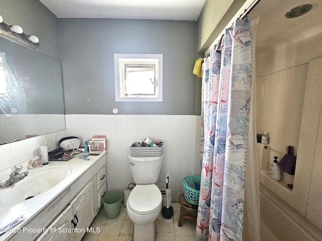 bathroom with a shower with curtain, vanity, toilet, and tile walls