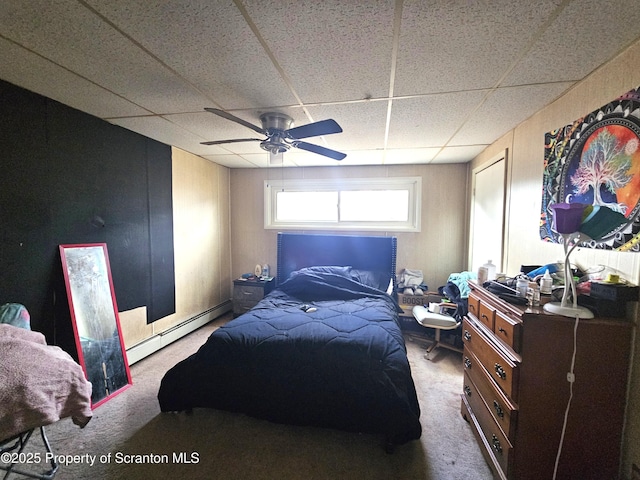 carpeted bedroom with a baseboard heating unit, a paneled ceiling, and ceiling fan