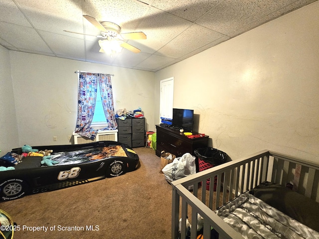 carpeted bedroom with a drop ceiling and ceiling fan