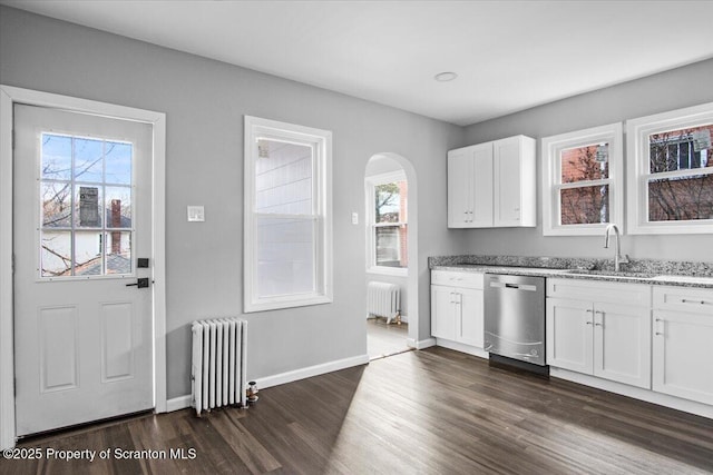 kitchen featuring stainless steel dishwasher, radiator, sink, and white cabinets