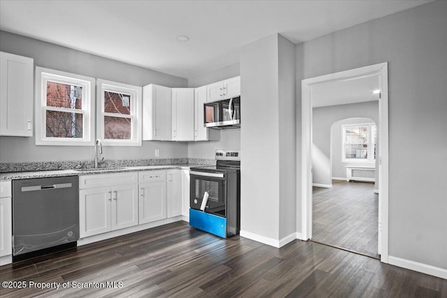 kitchen featuring sink, stainless steel appliances, dark hardwood / wood-style floors, light stone countertops, and white cabinets