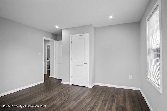 spare room featuring a wealth of natural light and dark hardwood / wood-style flooring